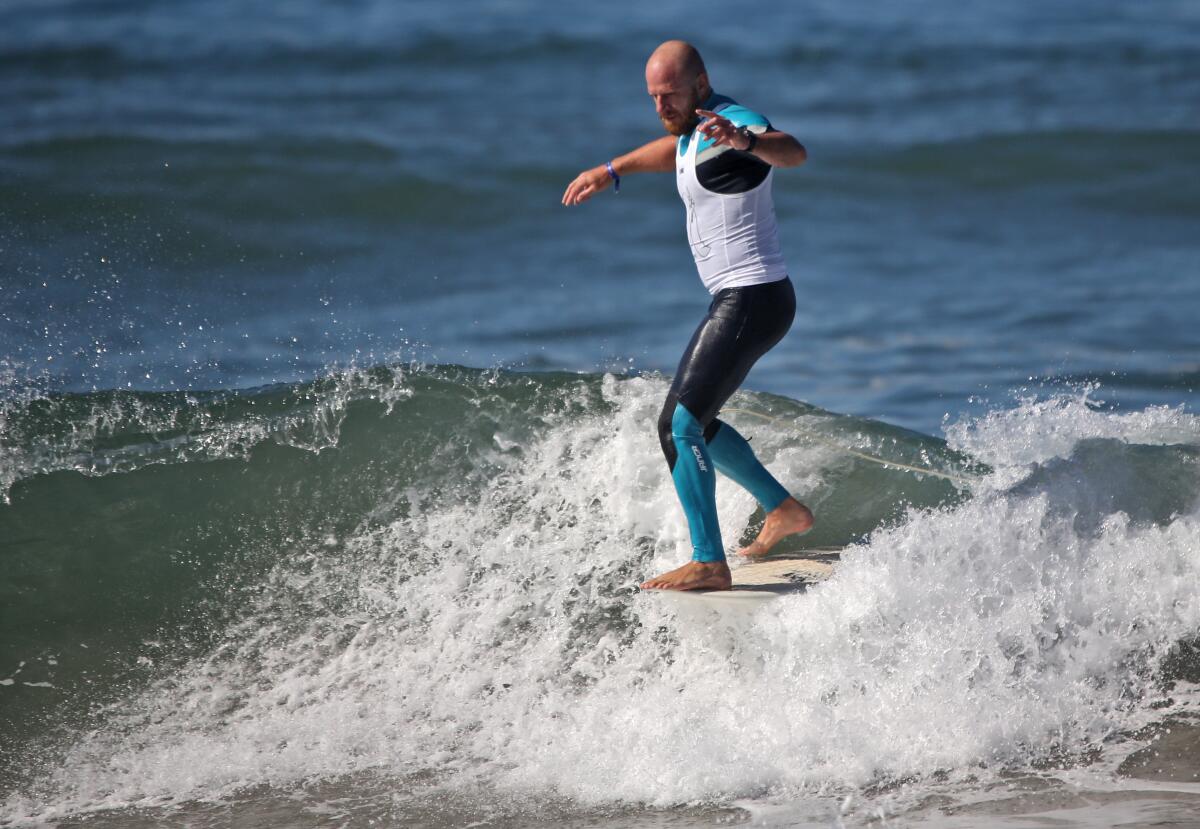 Phil Rajzman rides the longboard during the U.S. Open of Surfing, in Huntington Beach on Friday.
