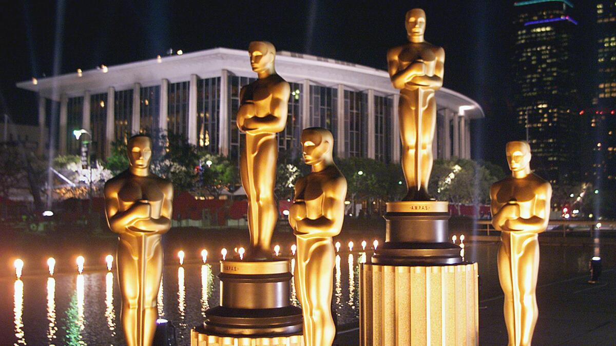 Replicas of Oscar statues are lit in the night outside the Dorothy Chandler Pavilion in March 1999, ahead of the 71st Academy Awards.