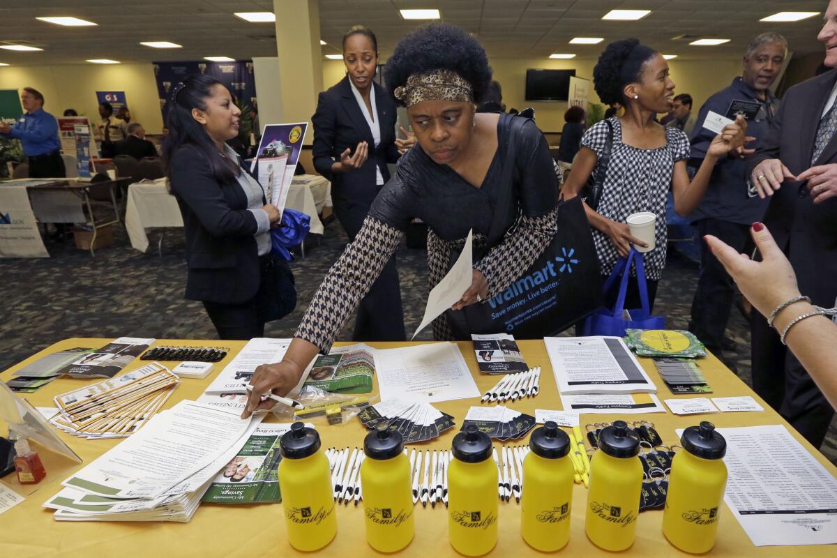 Army veteran Fay Belton picks up job information at the Veterans Career and Resource Fair in Miami on Feb. 6.