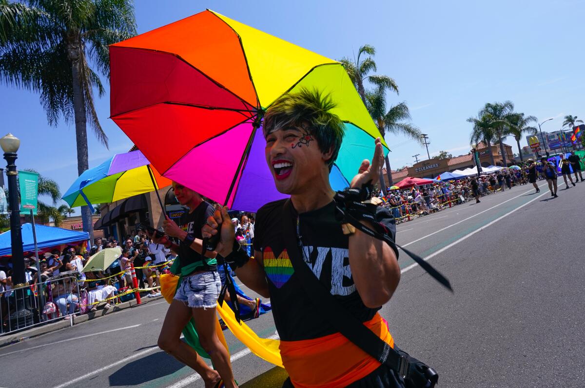 Crowd watches joyous San Diego Pride parade participants march, dance