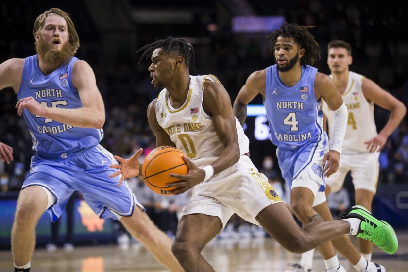 Notre Dame's Blake Wesley (0) drives by North Carolina's Brady Manek (45) during the second half of an NCAA college basketball game Wednesday, Jan. 5, 2022, in South Bend, Ind. (AP Photo/Robert Franklin)