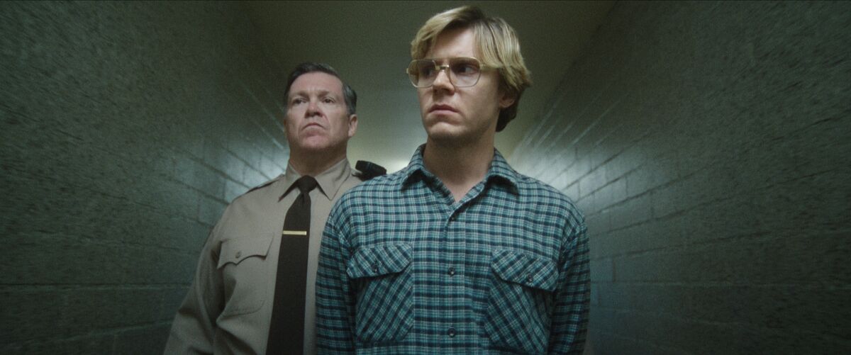 A police officer escorts a man down a hallway in "Dahmer -- Monster: The Jeffrey Dahmer Story."