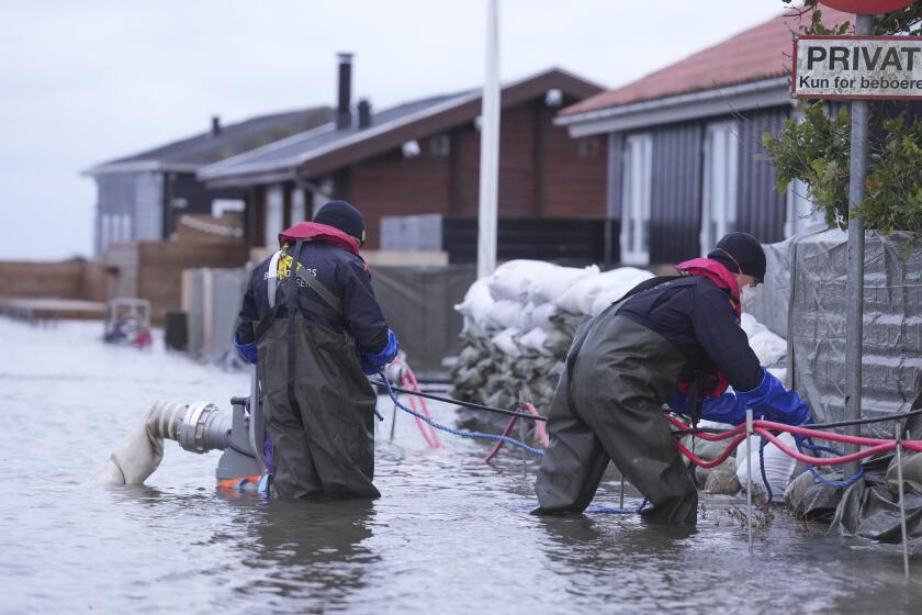 People try to pump water away in a flooded neighborhood in Haderslev, Denmark, Friday, Oct. 20. 2023. Authorities across Scandinavia on Friday urged vigilance as the region braced for heavy rain and gale-force winds from the east that was expected to culminate in the evening as a severe storm continued to sweep across northern Europe. The gale-force winds are expected to hit hardest in the eastern part of Denmark's Jutland peninsula and the Danish islands in the Baltic Sea. (Claus Fisker/Ritzau Scanpix via AP)