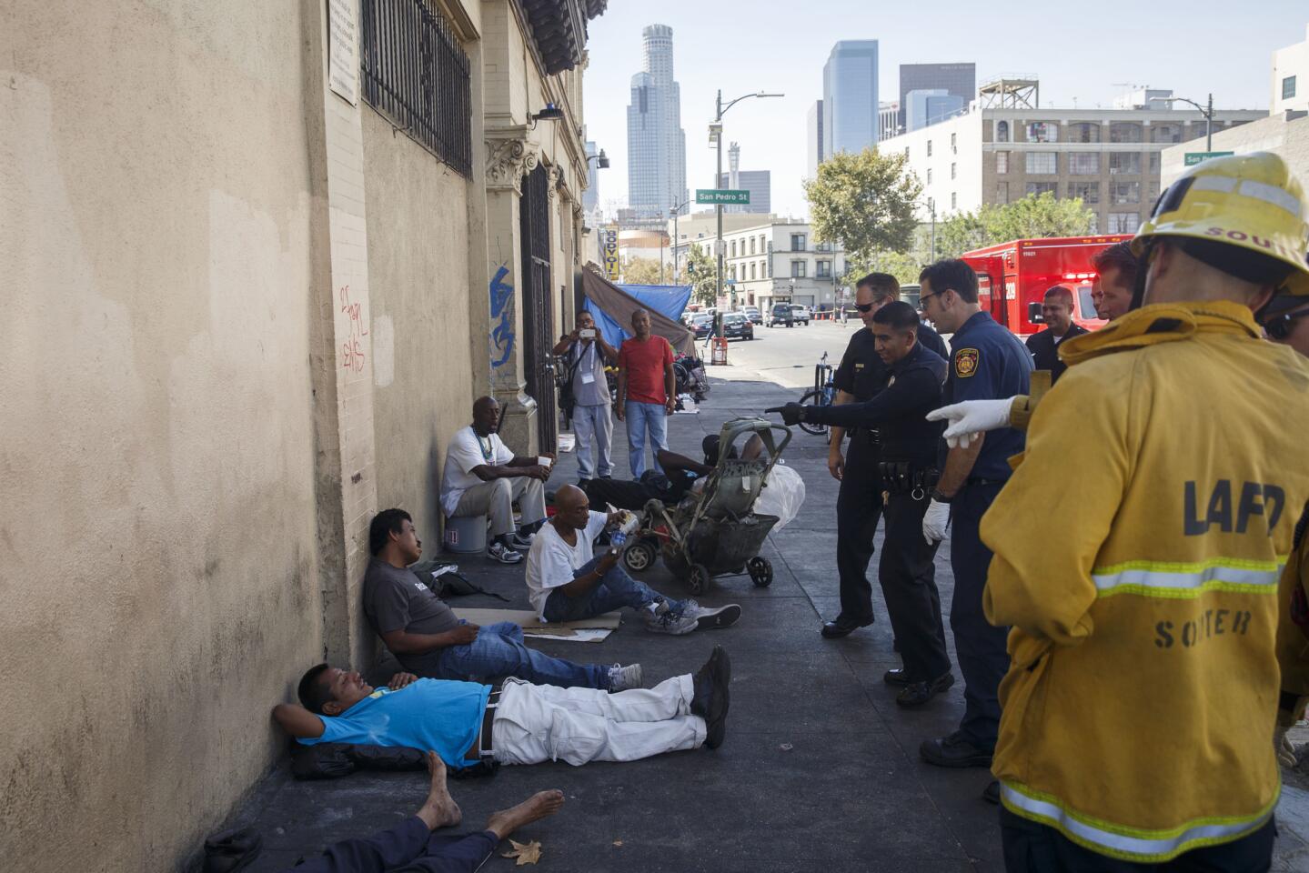 Paramedics and police officers respond to Los Angeles' skid row, where multiple people fell ill on Friday, Aug. 19, 2016.