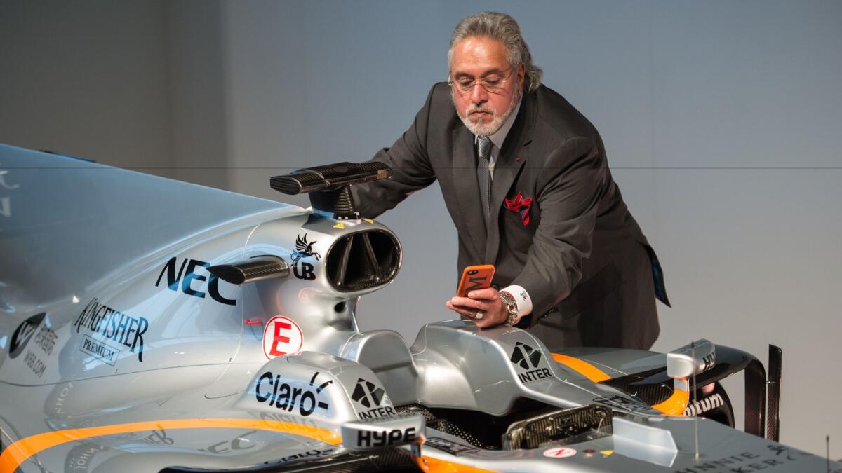 Businessman Vijay Mallya takes a picture of the Sahara Force India Formula One car for the 2017 season at a launch event at the Silverstone motor racing circuit near Towcester, central England, on Feb. 22, 2017.