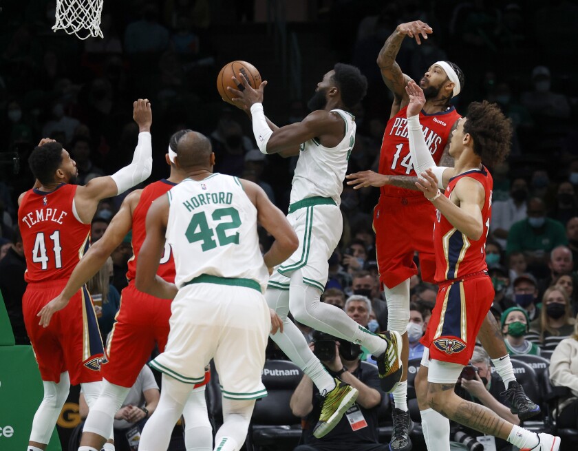 Boston Celtics guard Jaylen Brown (7) drives to the basket ahead of New Orleans Pelicans forward Brandon Ingram (14) during the first half of an NBA basketball game, Monday, Jan. 17, 2022, in Boston. (AP Photo/Mary Schwalm)