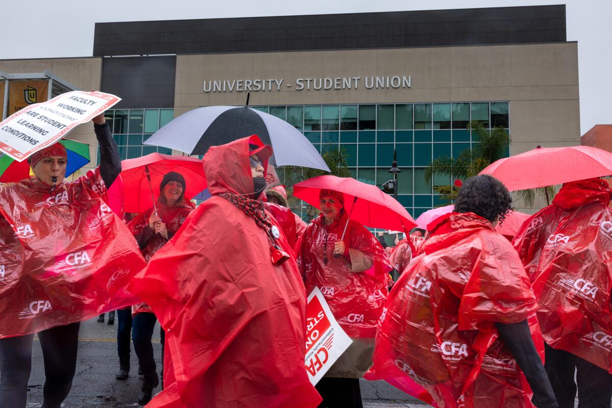 Members of the faculty union at Cal State Los Angeles brave the elements Monday morning as they begin a one-week strike.