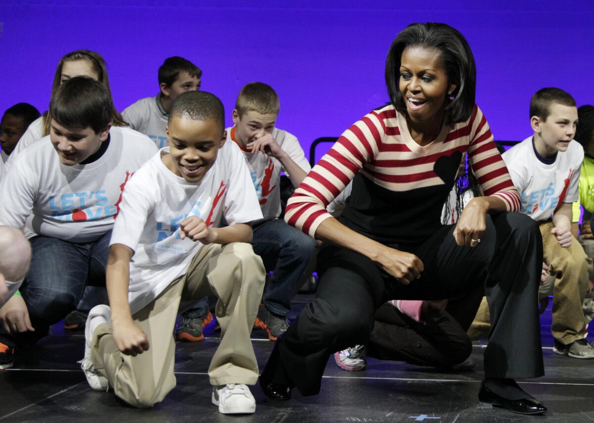 First Lady Michelle Obama does the "Interlude" dance during a Let's Move event with children from Iowa schools at the Wells Fargo Arena in Des Moines, Iowa in 2012.