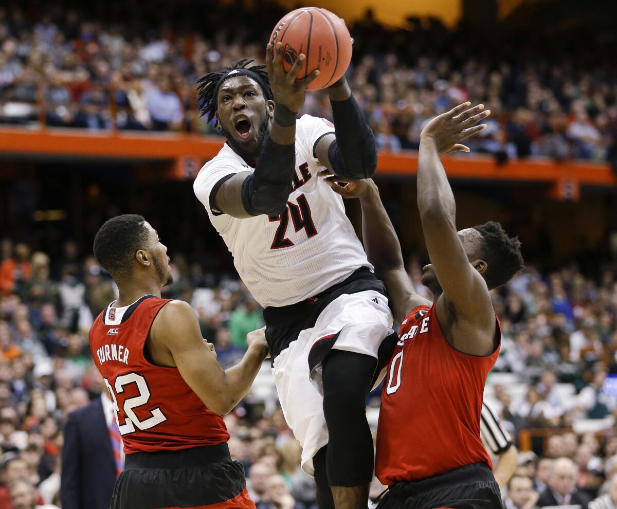 Louisville's Montrezl Harrell (24) drives past N.C. State's Ralston Turner (22) and Abdul-Malik Abu (0) during the first half of an NCAA tournament game on March 27.