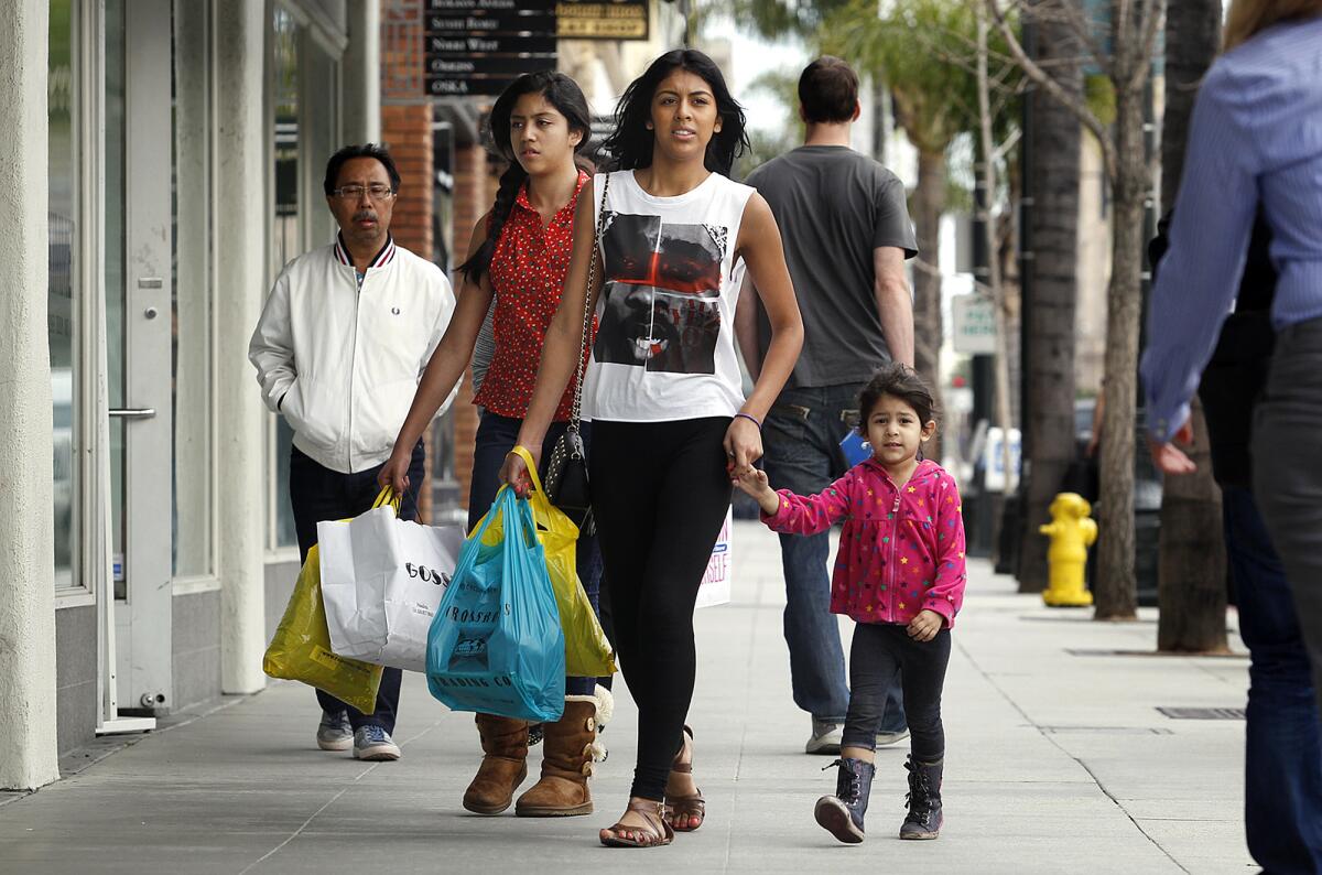 Jaismine Alas, 18, of Pasadena, center, and her sisters Melanie Alas, 12, left, and Ashley Rubalcava, 3, shop on Colorado Boulevard in Pasadena on March 6, 2013.