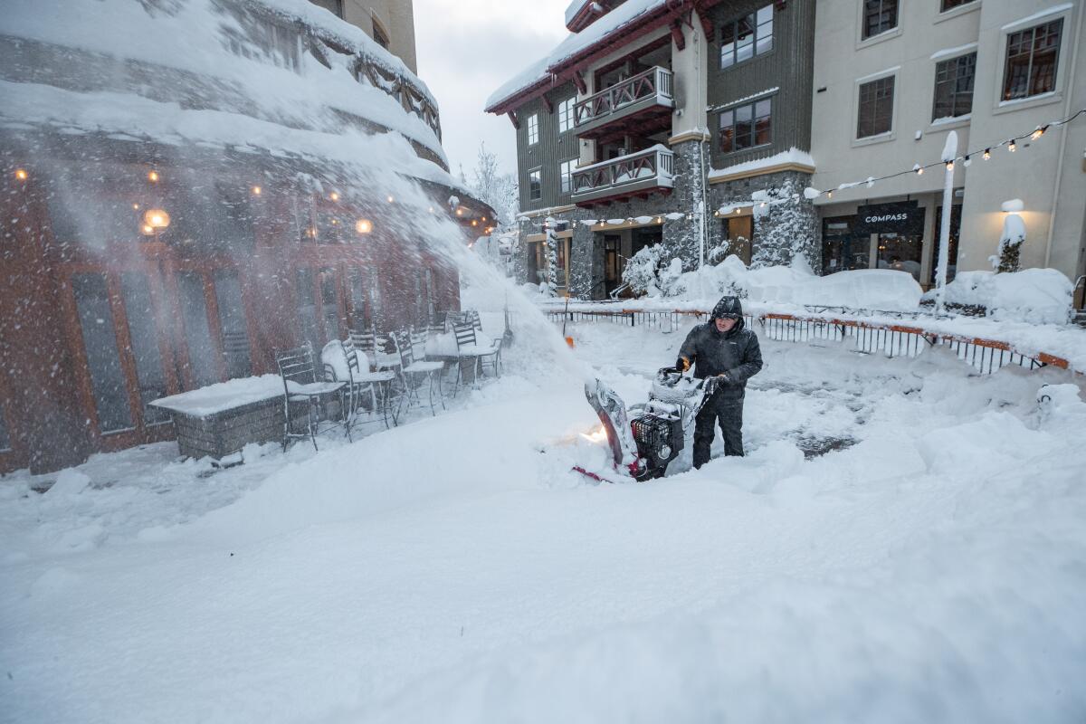 A person operates a snow blower. 