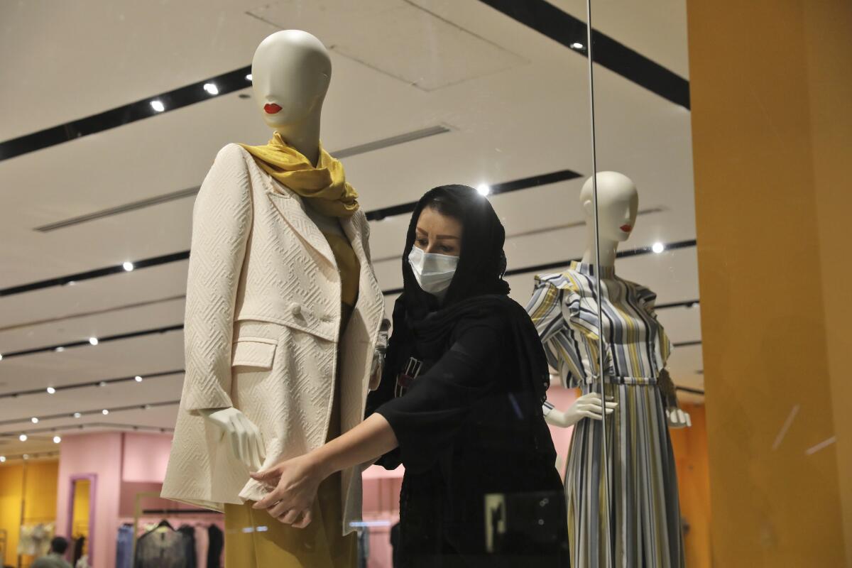 A shopkeeper adjusts a jacket on a mannequin at Iran Mall shopping center in Tehran, Iran, Wednesday, June 9, 2021. The West considers Iran's nuclear program and Mideast tensions as the most important issues facing Tehran, but those living in the Islamic Republic repeatedly point to the economy as the major issue facing it ahead of its June 18 presidential election. (AP Photo/Vahid Salemi)