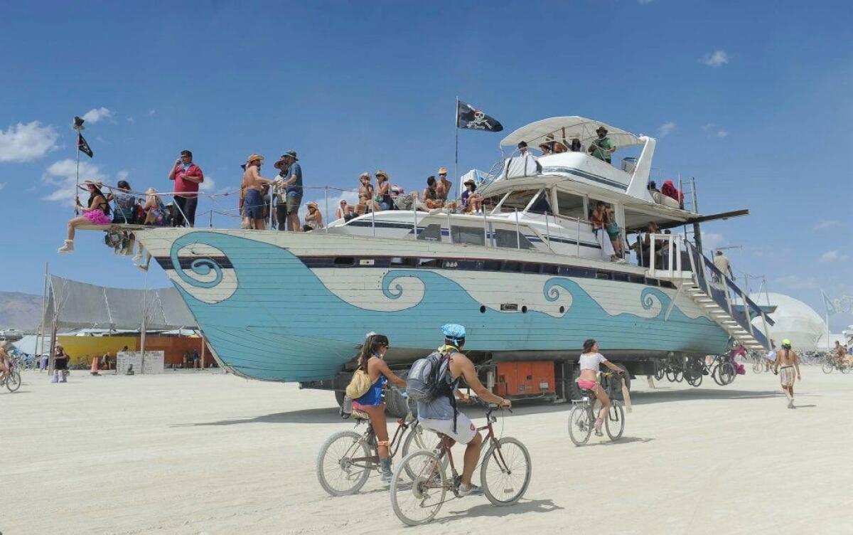 In this Aug. 31, 2012, photo, an old wooden yacht art car rolls through the playa at Burning Man.