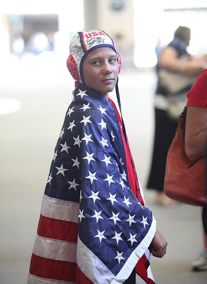Superfan Zach Cwiertnia shows his support as he waits for the gold medal-winning women’s Olympic water polo team members at John Wayne Airport on Tuesday.