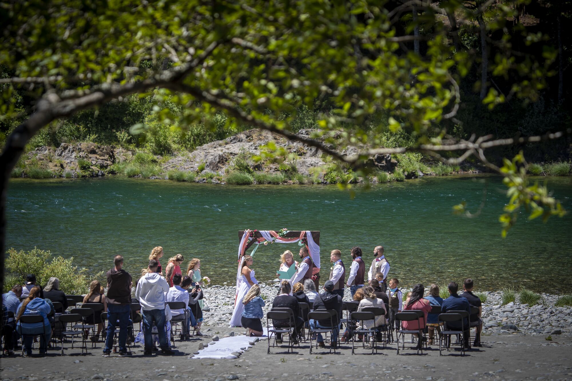A wedding ceremony takes place at Jedediah Smith Redwoods State Park along the Smith River.