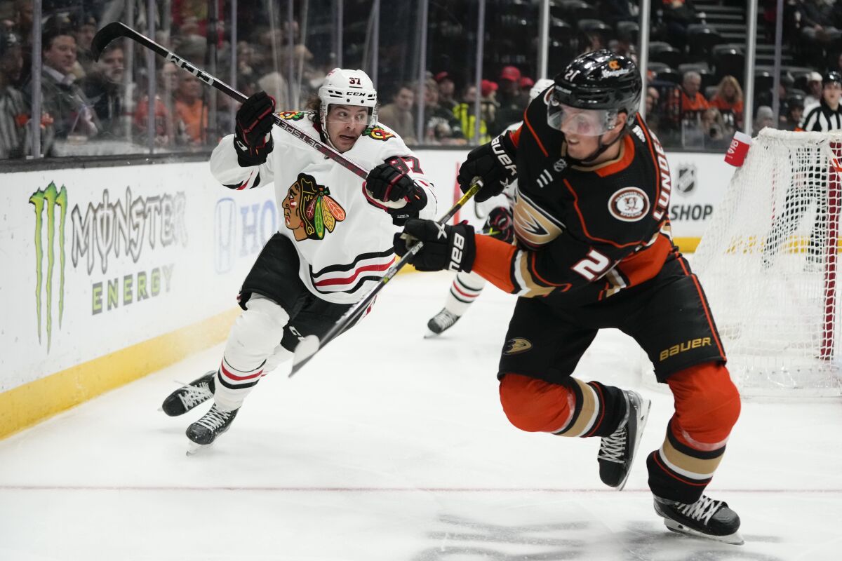 Chicago Blackhawks forward David Gust, left, and Ducks forward Isac Lundestrom chase after the puck.