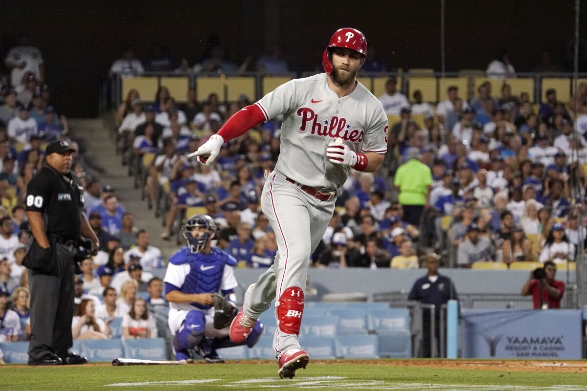 Philadelphia Phillies star Bryce Harper gestures toward his dugout after hitting a three-run home run.