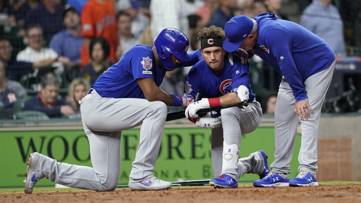 Chicago Cubs' Albert Almora Jr., center, is comforted by teammate Jason Heyward and manager Joe Maddon after hitting a foul ball that struck a young girl May 29 in Houston.