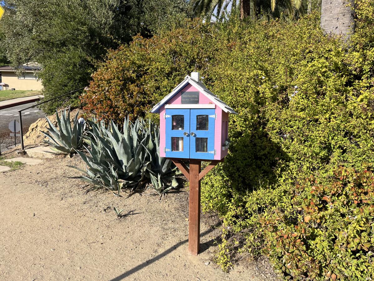 A Little Free Library is posted outside a home.