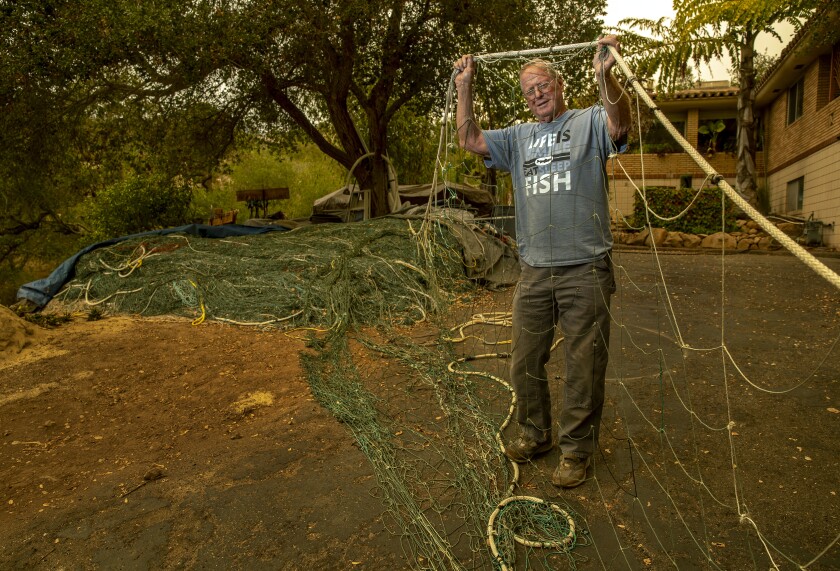 Gary Burke holds up a section of his mile-long nylon net that he uses to catch swordfish.