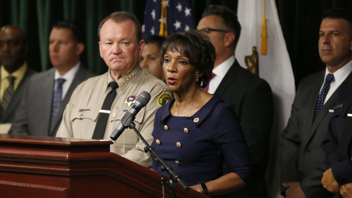 L.A. County Sheriff Jim McDonnell, front left, and L.A. County Dist. Atty. Jackie Lacey have refused to disclose records that are public under California law, according to a lawsuit filed this week by the Los Angeles Times.