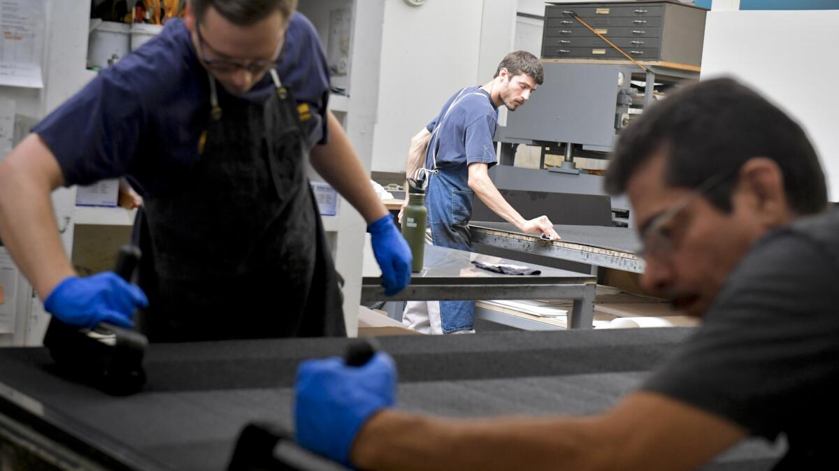 Master printer Xavier Fumat, foreground, lays ink for a copper etching that will be used to make Richard Serra prints at Gemini G.E.L. Fumat has worked with the artist for 18 years.