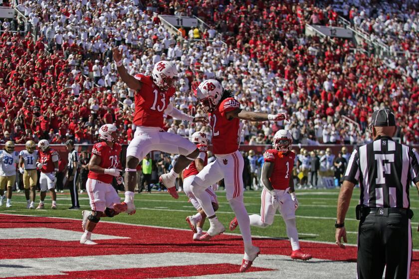 Utah's Landon King (82) celebrates his touchdown with quarterback Nate Johnson (13) during the first half of an NCAA college football game against UCLA, Saturday, Sept. 23, 2023, in Salt Lake City. (AP Photo/Rick Bowmer)