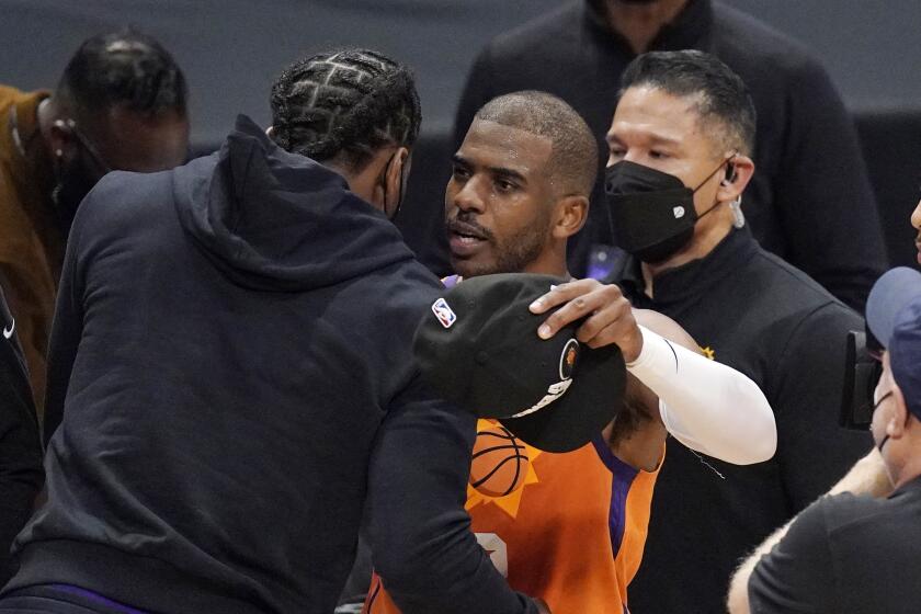 Phoenix Suns guard Chris Paul, center, hugs Los Angeles Clippers' Kawhi Leonard after the Suns won Game 6 of the NBA basketball Western Conference Finals against the Los Angeles Clippers Wednesday, June 30, 2021, in Los Angeles. The Suns won the game 130-103 to take the series 4-2. (AP Photo/Mark J. Terrill)