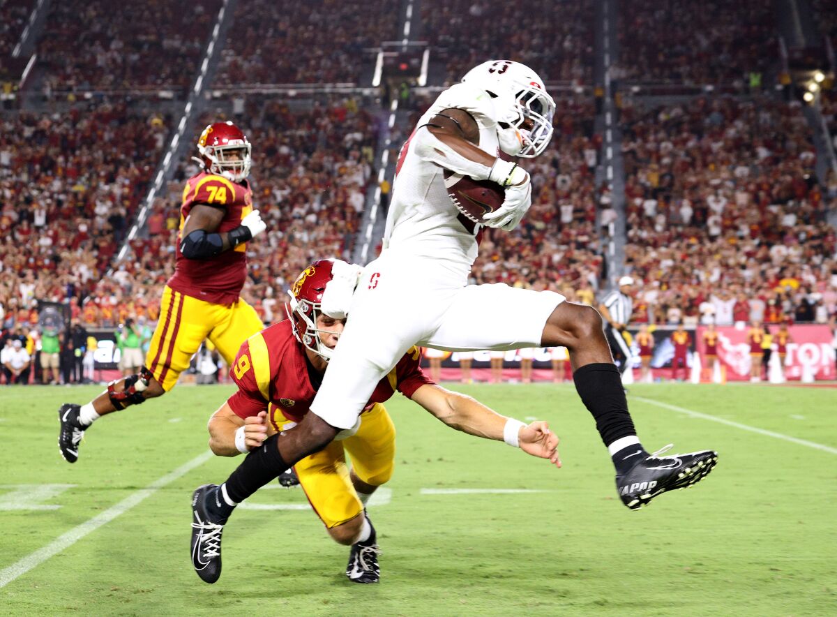 Stanford's Kyu Blu Kelly sprints past USC quarterback Kedon Slovis on a interception return for a touchdown.