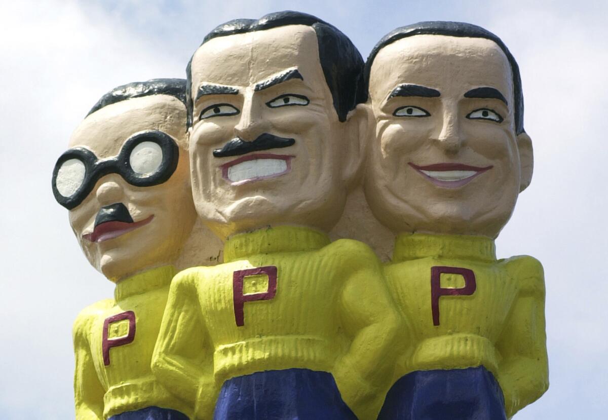 This file photo from July 31, 2003 shows Pep Boys mascots Manny, Moe, and Jack above a store location in West Philadelphia. Tire and auto service company Bridgestone on Monday, Oct. 26, 2015 said it is buying auto parts and repair company Pep Boys in a deal that will help it gain a more dominant position.