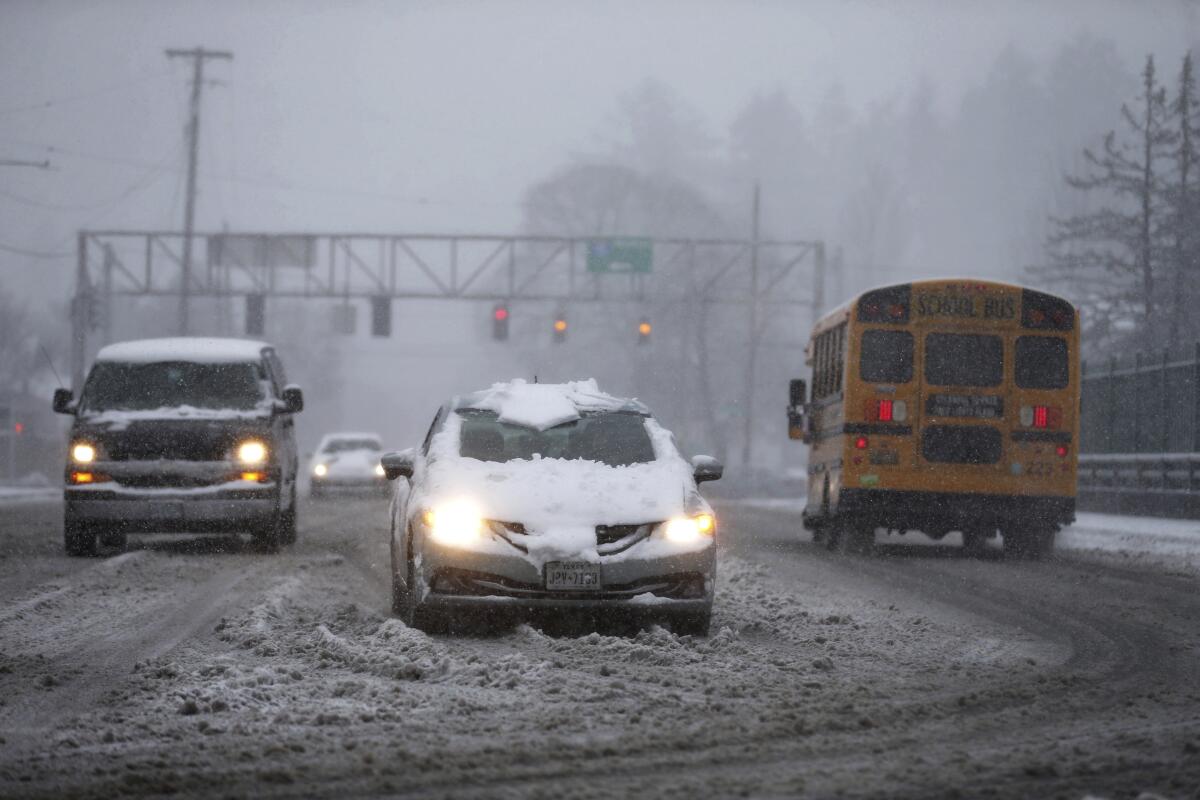 Vehicles on a snowy road in Portland, Ore.