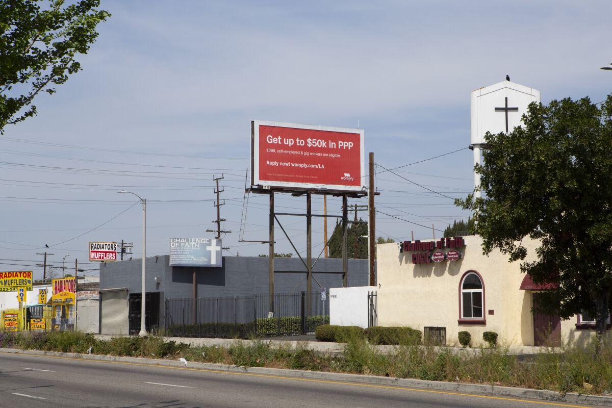 A red billboard advertising PPP loan assistance