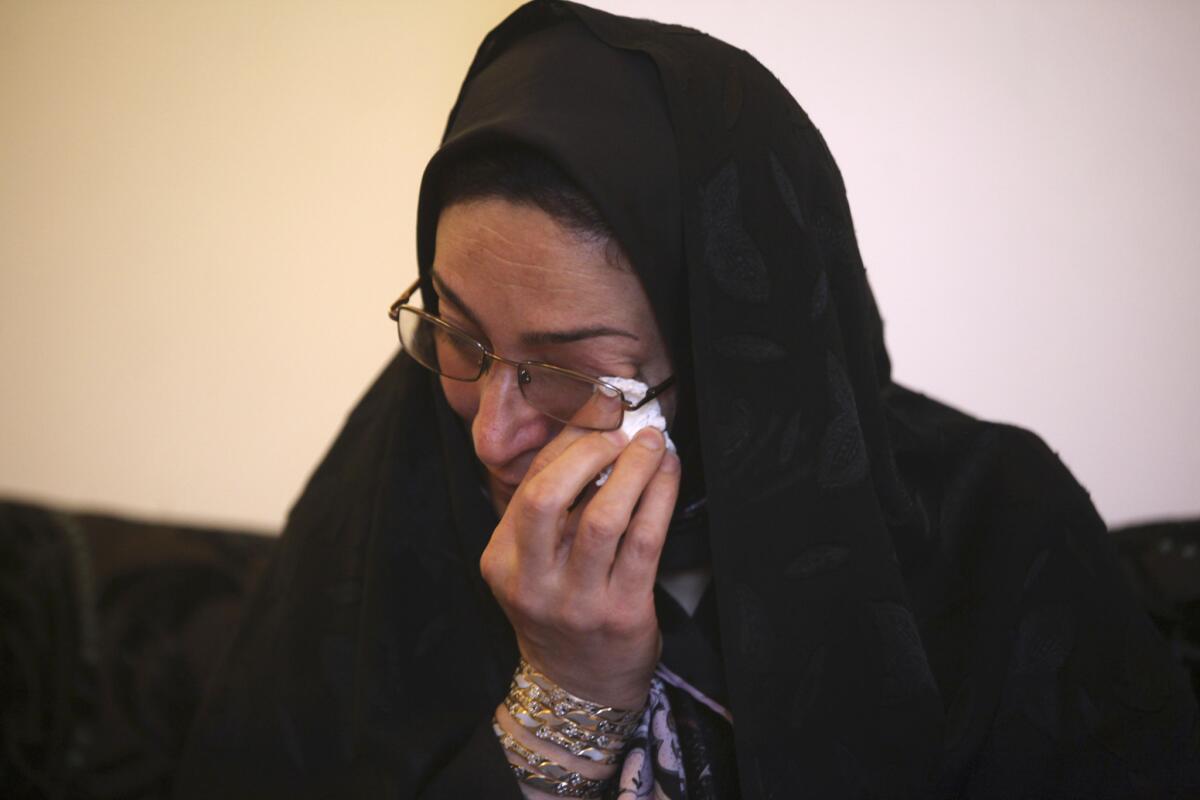 Samereh Alinejad wipes away tears at her home while talking about her son who was killed in a street brawl in Iran. Alinejad told The Associated Press that she had felt she could never live with herself if the man who killed her son were spared from execution. But in the last moment, she pardoned him in an act that has made her a hero in her hometown, where banners in the streets praise her family's mercy.