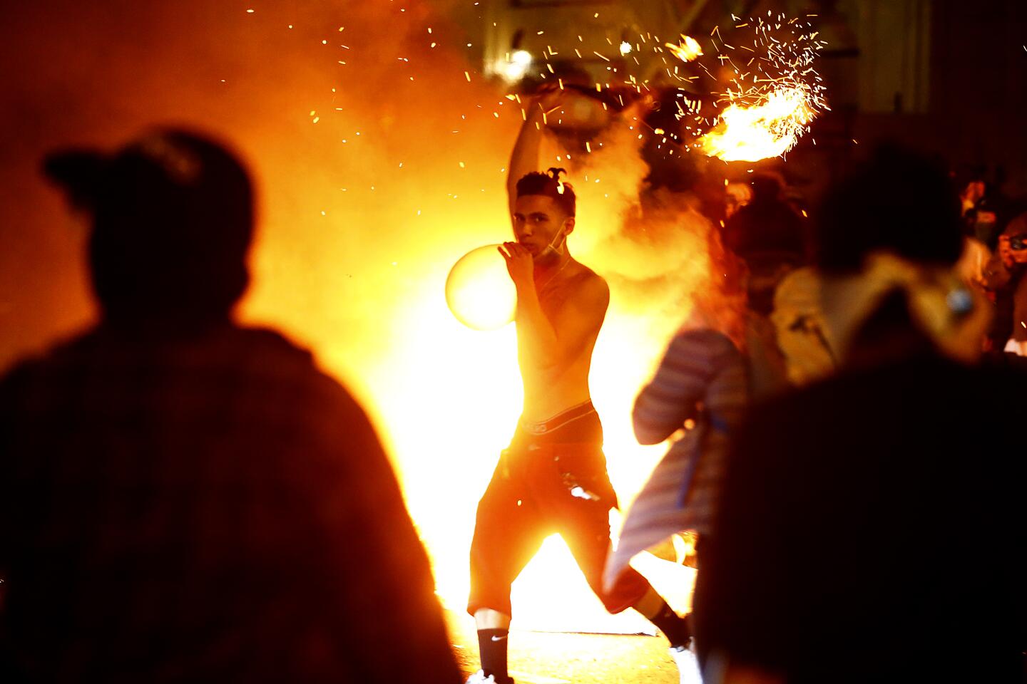 Protesters gather around a fire in the middle of a downtown L.A. street on Friday.
