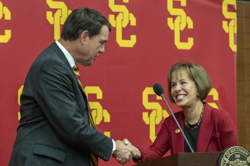 LOS ANGELES, CALIF. -- THURSDAY, NOVEMBER 7, 2019: New USC athletic director Mike Bohn, left, shakes hands with USC President Carol L. Folt, right, during news conference on the USC campus in Los Angeles, Calif., on Nov. 7, 2019. (Brian van der Brug / Los Angeles Times)