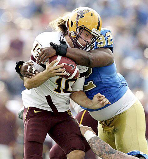 Bruins defensive tackle Brian Price wraps up Arizona State quarterback Samson Szakacsy for a sack in the first half Saturday.