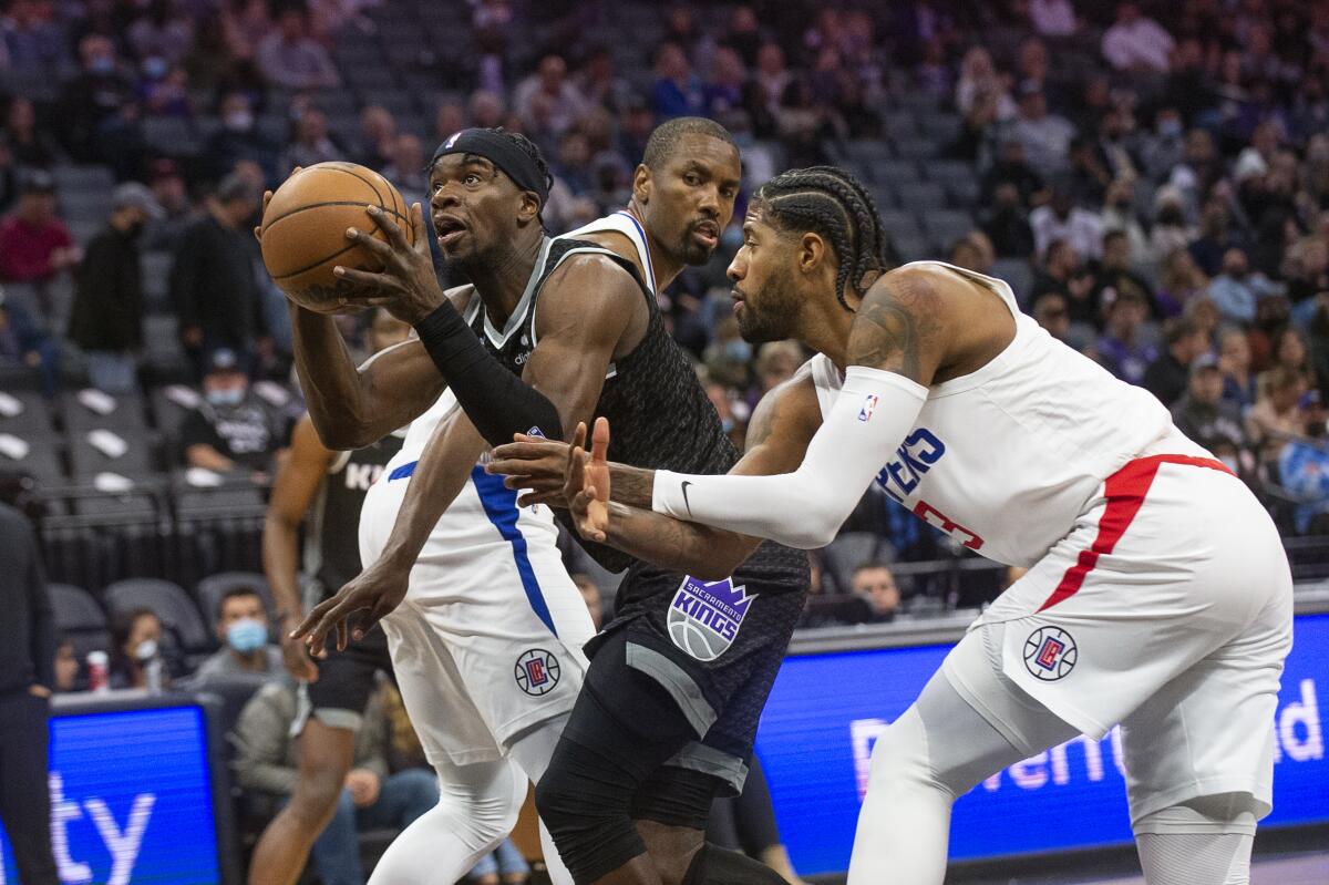 Sacramento Kings guard Terence Davis drives to the basket past Clippers center Serge Ibaka and forward Paul George.