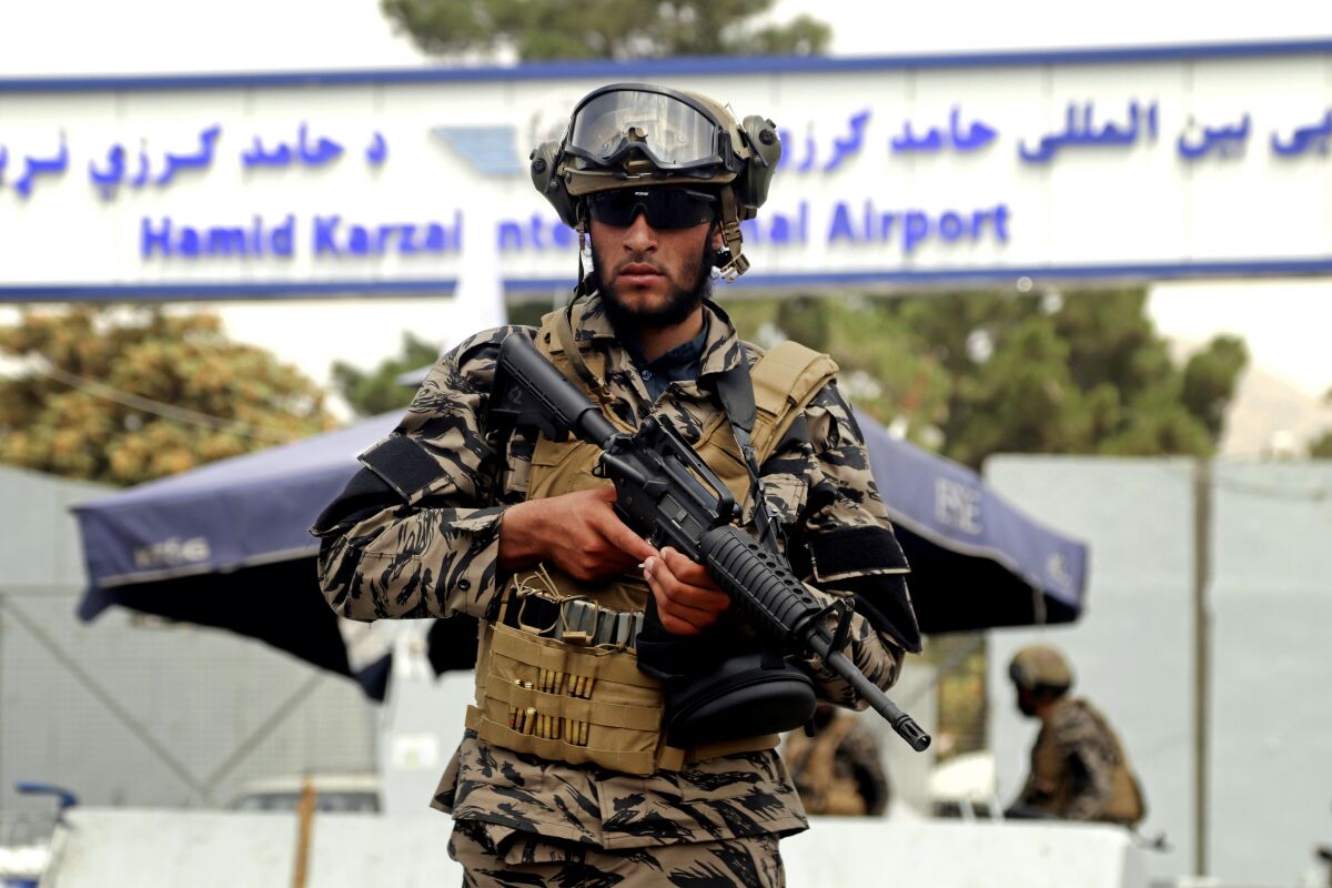 A Taliban fighter stands guard outside Kabul airport. 