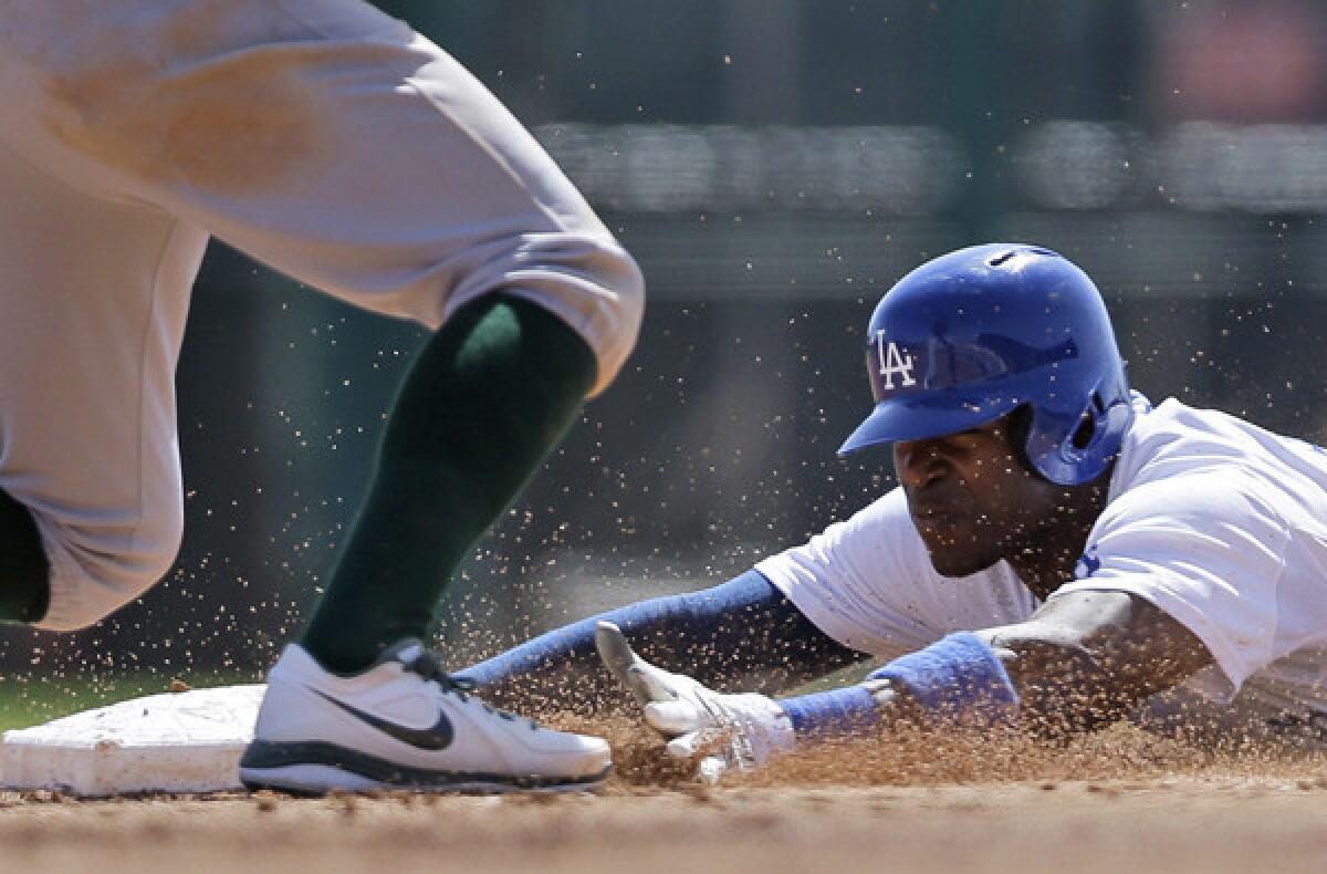 Dodgers outfielder Yasiel Puig slides safely into second base with a steal against the A's during an exhibition game this spring.