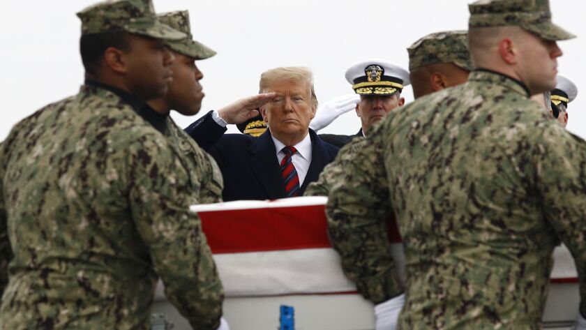 President Trump salutes as a U.S. Navy team moves a case containing the remains of Scott A. Wirtz on Jan. 19, 2019, at Dover Air Force Base. According to the Department of Defense, Wirtz was killed on Jan. 16 in a suicide bomb attack in Manbij, Syria.