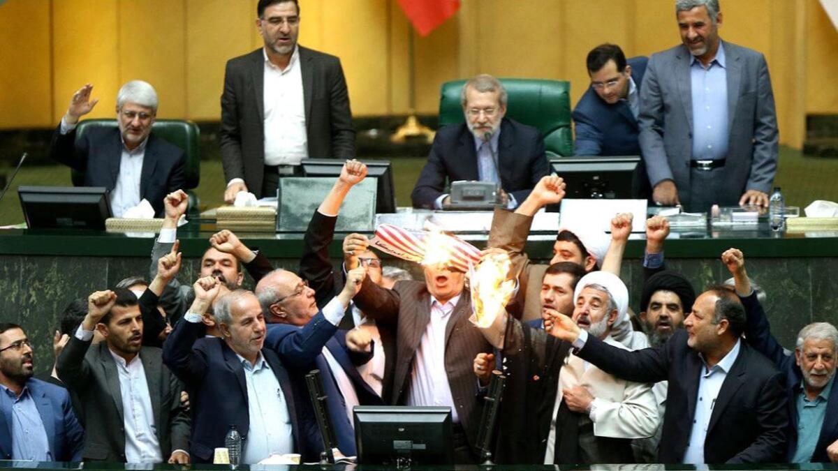 Members of Iran's parliament burn a U.S. flag in Tehran on Wednesday.
