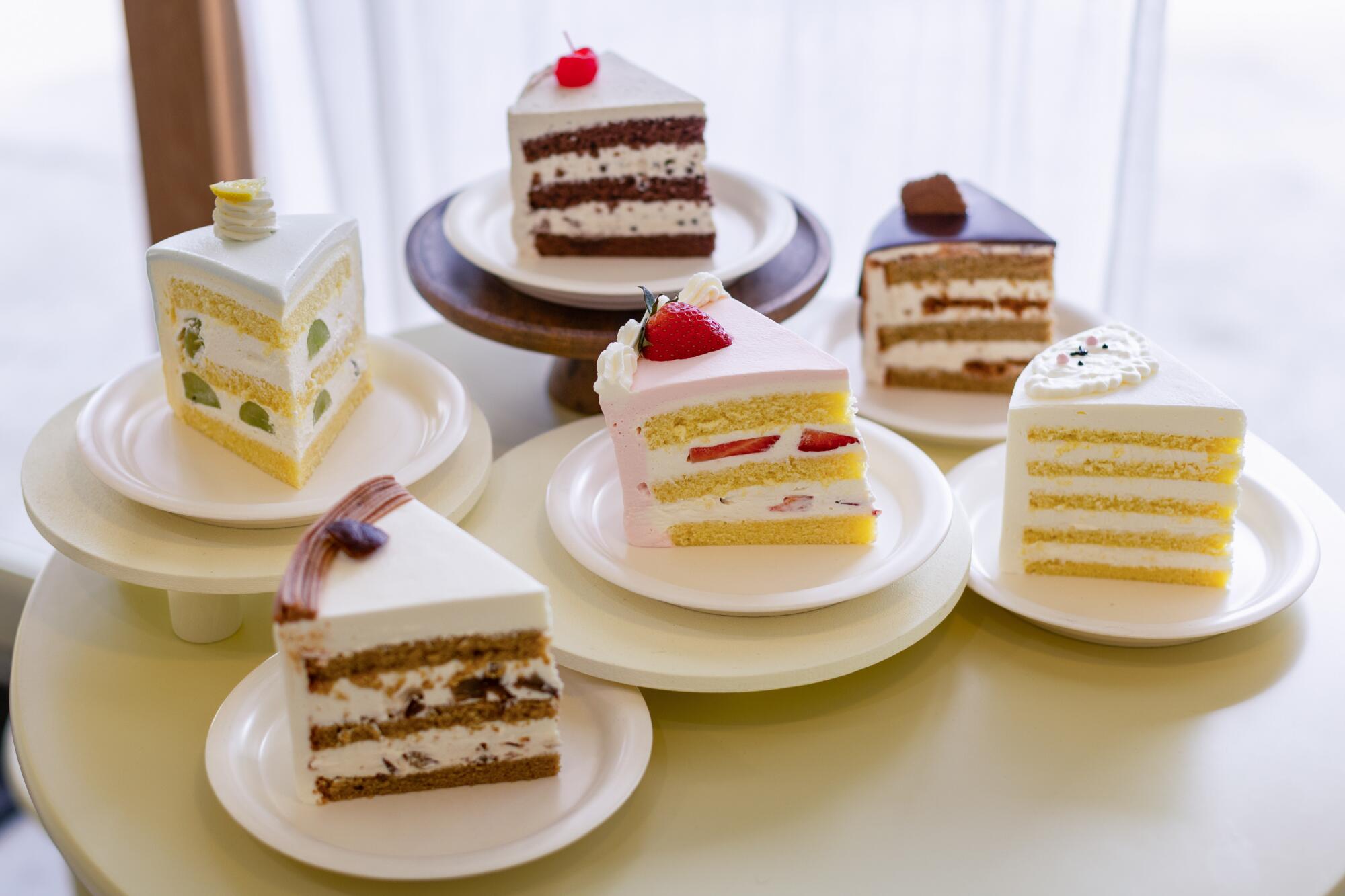 Six wedge-shaped slices of different layered cakes at Harucake. 