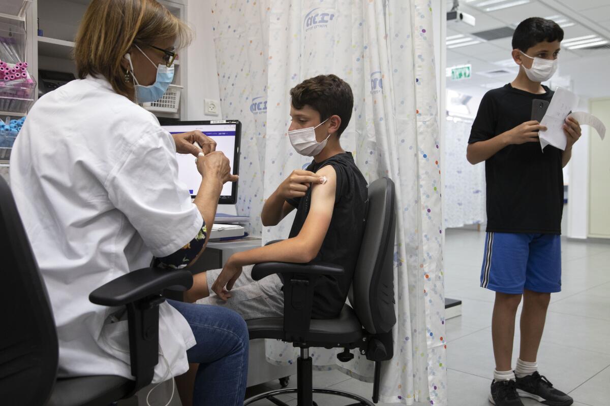 A young person receives a PfizerCOVID-19 shot in Rishon LeZion, Israel, in June.