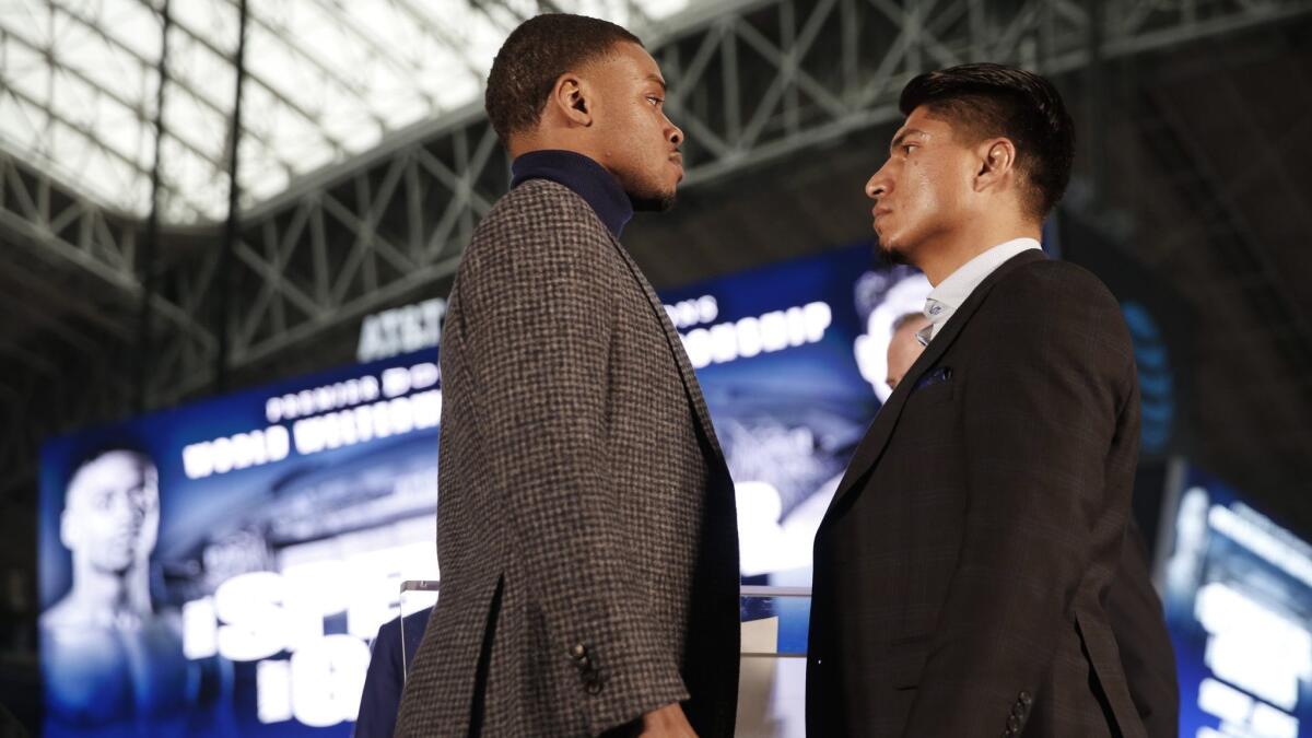 Errol Spence, left, and Mikey Garcia stare each other down during a news conference on Feb. 19 promoting their upcoming bout.