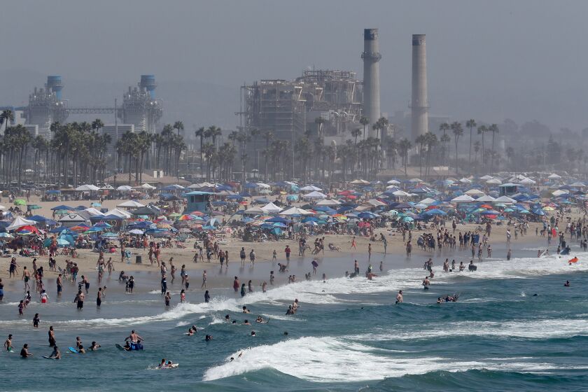 HUNTINGTON BEACH, CA - SEP. 5, 2020. A Labor Day weekend crowd descends on Huntington Beach as a heatwave grips Southern California, with valley and inland temperatures reaching high into the triple digits on Saturday, Sept. 5, 2020. Extreme heat health advisories and red flag fire warnings are in effect through the holiday. (Luis Sinco / Los Angeles Times)