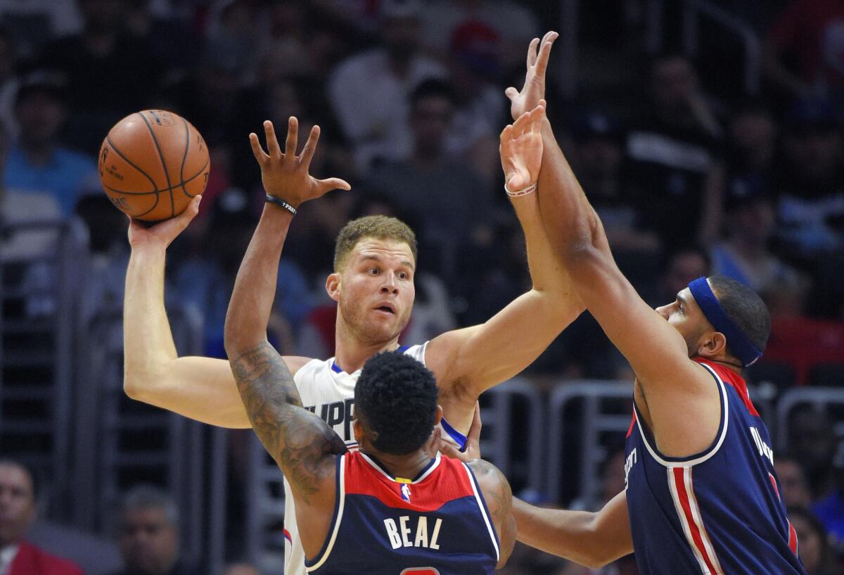 Clippers forward Blake Griffin tries to pass the ball as Wizards guard Bradley Beal, left, and forward Jared Dudley double team him during the second half.