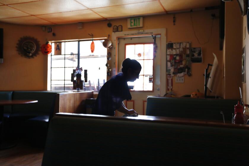 Maria Hernandez of Veronica's Kitchen in Descanso cleans tables at the restaurant after power was shut off and it had to close for the day on October 24, 2019. The power was shut off by SDG&E because of high winds in the area.