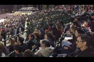 People attend vigil for shooting victims at San Manuel Stadium in San Bernardino