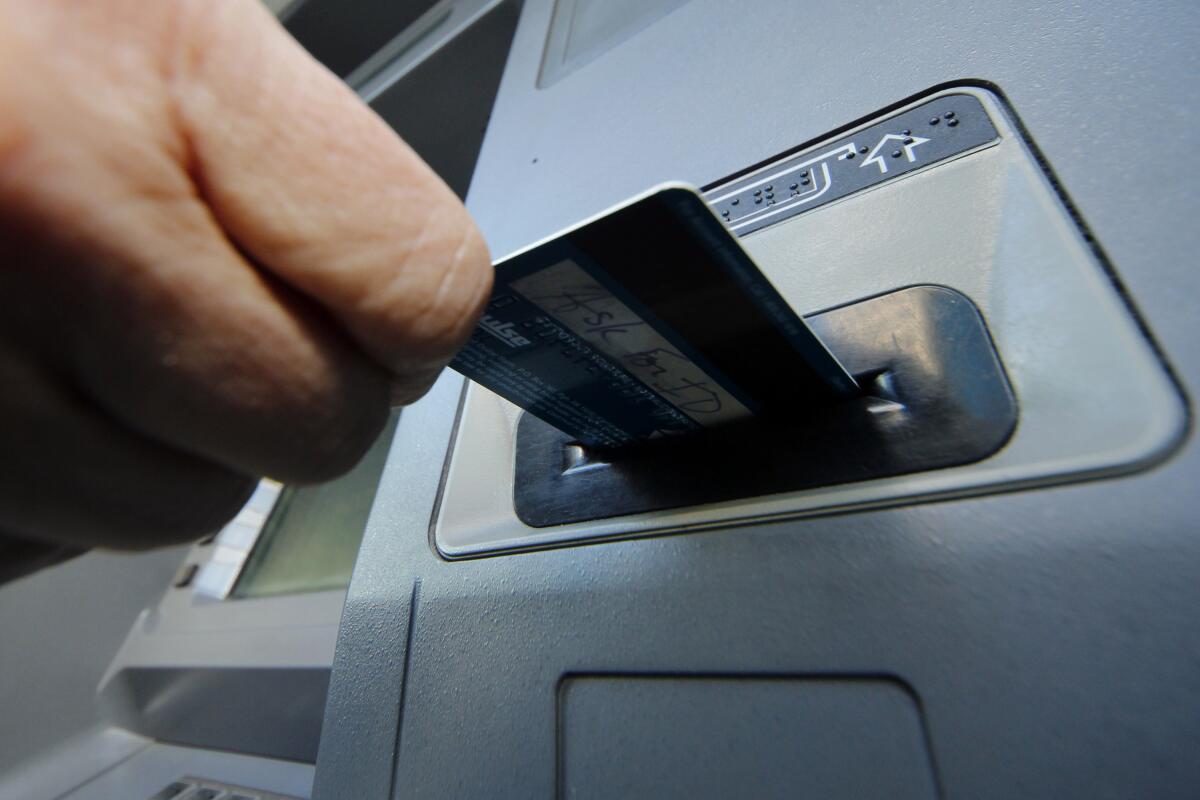 A debit card is inserted into an ATM slot