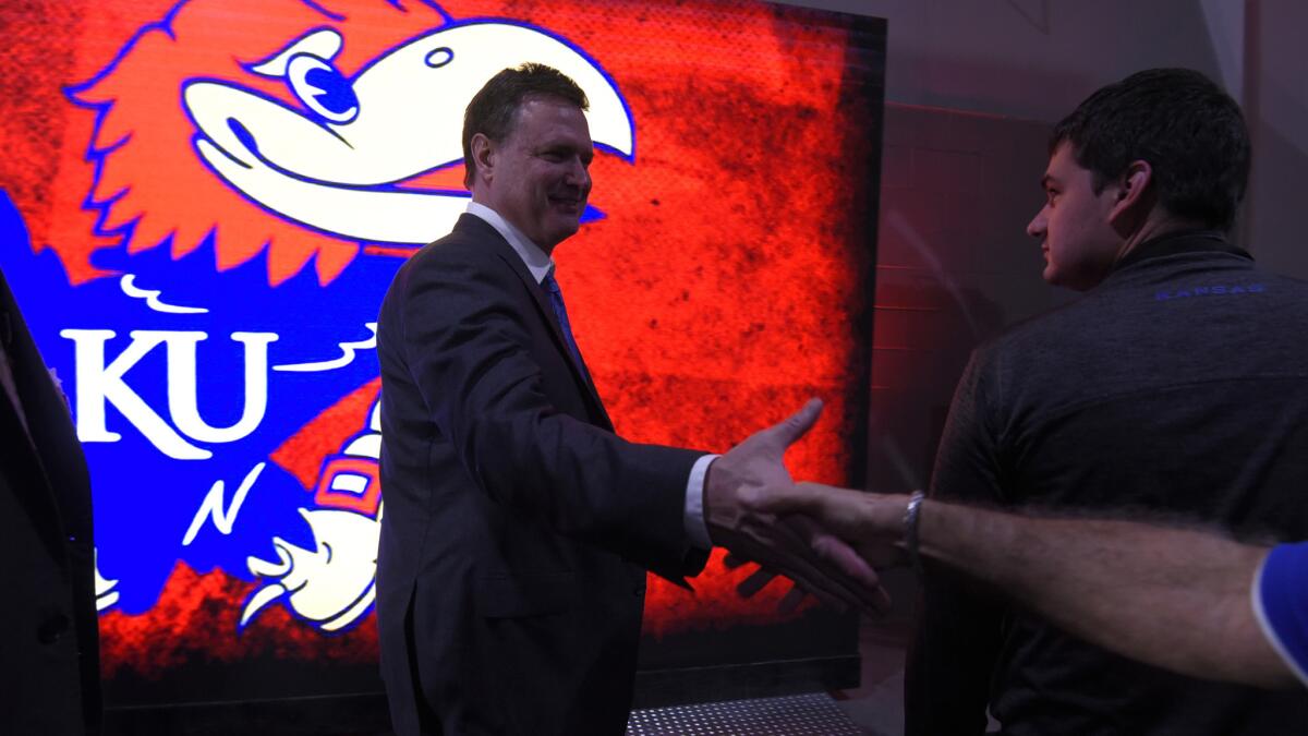 Kansas Coach Bill Self is congratulated by a fan after the top-ranked Jayhawks won the Big 12 Conference tournament title on Saturday.